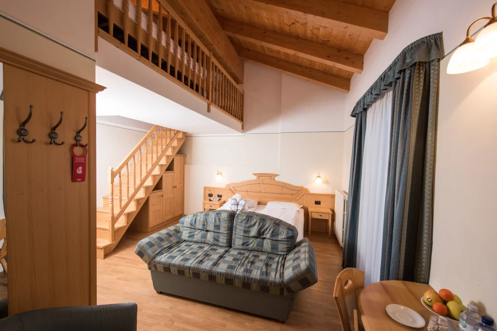 Camera d'albergo con soppalco, letto matrimoniale e arredamento in legno.