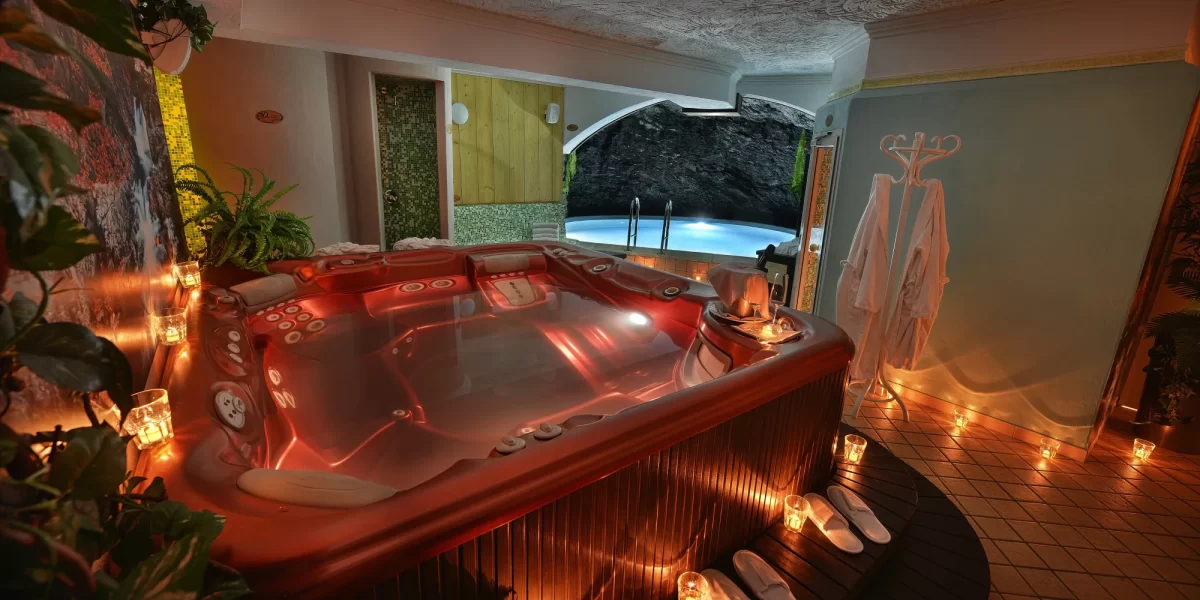 Vasca idromassaggio lussuosa in una spa con illuminazione soffusa e candele.